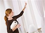 Attractive woman cleaning window holding paper towel. horizontal