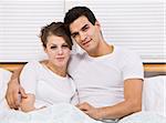 Male and female attractive couple snuggling in bed, horizontally framed