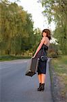 young woman waitin a car from the roadside