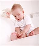 Portrait of cute newborn playing with his toe