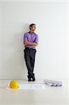 portrait of mid adult architect leaning on wall and looking away. Copy space