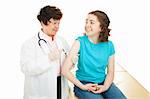 Caring female doctor giving a vaccination to a nervous teen girl.  Isolated on white.