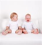 Two swert babies - one looking, one crying