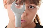 Young woman builder at work with big french key, isolated on white - focus on key