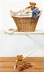 Laundry basket with teddy bears on pine floor