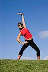 Young pretty woman exercising isolated on blue sky