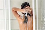 Young woman in shower washing her hairs