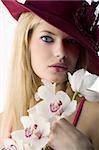 beautiful young woman with red hat and some orchid looking surprised