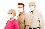 Senior couple and their adult son wearing surgical masks to protect from flu epidemic.  Isolated.