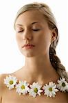 closed eyes portrait of a beautiful woman with twist braid and a flowers necklace