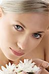 close up on face of cute girl with big eyes and some white daisy in hand