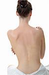 Concept de soins de la peau : l'arrière de la belle femme nue avec peau molle de mettre des produits soins de la peau (crème) sur son dos