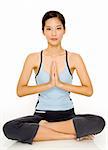 A pretty young asian woman in a meditative yoga pose