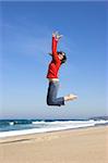 Young woman jumping on the beach