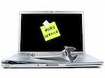 Damaged laptop with a post-it in french meaning Out of Service and a spanner over it. Isolated on white.