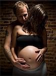Ein Mann hält seine schwangere Frau in den Bauch.
