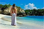 Beautiful brunette with long hair walking along the sandy beach on Bali