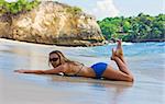 Jeune fille blonde se trouvant dans le surf sur la plage sur Bali