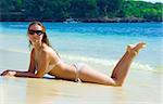Belle brune jeune fille relaxante sur la plage de sable sur l'île de Bali en Indonésie