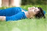 jolie femme reposante sur l'herbe dans le parc