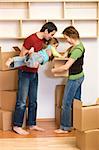 Family unpacking from lots of cardboard boxes in their new home - moving concept