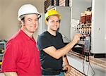 Apprentice electrician and his instructor reading the voltage on a power distribution center.