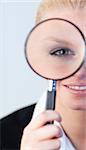 young attractive Smiling woman looking into a magniying glass