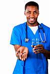 Portrait d'un jeune médecin afro-américain dans scrubs pilules et verre de l'eau, souriant à la caméra