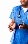 Zuversichtlich afroamerikanischen Arzt holding Pillen und Glas Wasser vor der Kamera