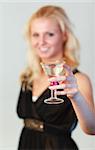 Glamorous blonde woman holding a cocktail focus on cocktail