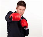 Young attractive businessman with boxing gloves and focus on gloves