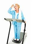 Senior lady on a treadmill mops sweat from her forehead with a towel.  She doesn't like working out.  Isolated.