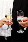 Glasses of champagne in a hand of the groom and bride