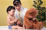 Cheerful baby at the doctor,playing with toy bear.