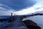 Sunset on a pier in Grand Marais with a glowing lighthouse