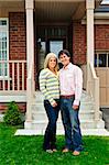 Happy Young couple debout en face de la maison