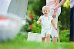 Child running outside by women hanging laundry on clothesline