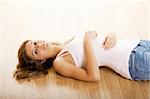 Beautiful young woman lying on floor and relaxing