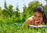 Jeune femme séduisante, lire un livre posé sur l'herbe