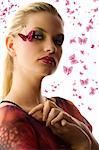 Beautiful woman in fashionable dress with creative makeup with butterfly on her face