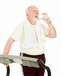 Senior man on treadmill takes a break to drink from a water bottle.  Isolated on white.