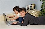 La sœur et le frère junior jouent sur un ordinateur.