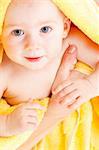 Closeup portrait of a baby covered with yellow towel