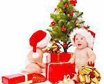 Bébés à la recherche de leurs cadeaux sous l'arbre de Chistams