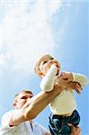 Baby boy flying on his dad's hands