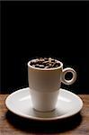 Nice image of an expresso cup and saucer with beans and a black background