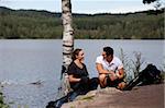 A man and woman taking a break while on a camping hike