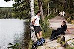 Un couple de randonnée dans les bois faire une pause au bord du lac