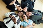 Business people lying in a circle on the floor of the office