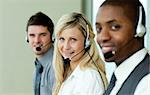Drei Geschäftsleute arbeiten im Büro mit headsets